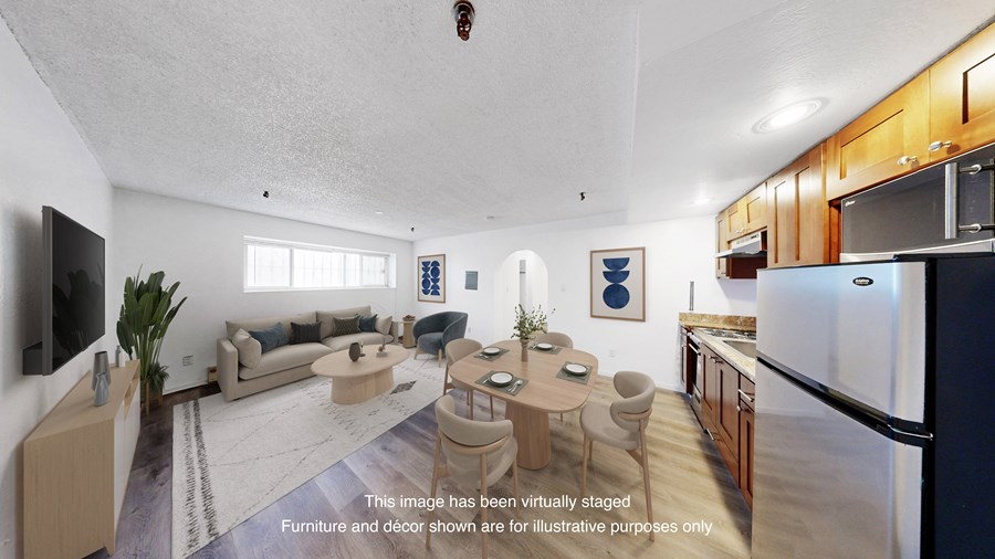 A modern kitchen with a dining table and chairs in the middle of the room.